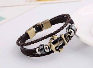 Close-up of multi-layer braided leather bracelet featuring a bronze anchor charm detail