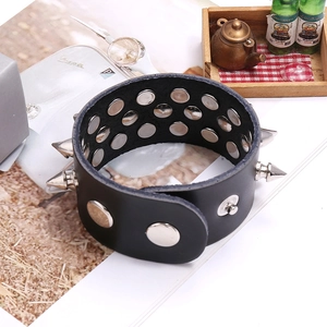 Detail of black punk leather bracelet featuring two rows of studs and silver metal spikes