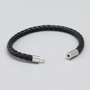 Dettaglio del bracciale in pelle intrecciata nera con chiusura lucida in acciaio inossidabile