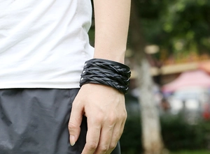 Close-up of black punk leather woven bracelet with silver metal studs on a male wrist