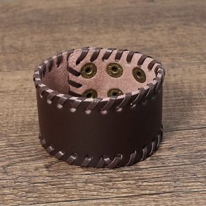 Close-up of vintage brown leather woven bracelet with adjustable bronze snap buttons