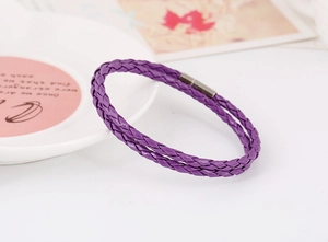 Macro detail of purple double-braid leather bracelet with dark grey magnetic clasp
