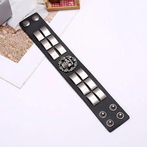 Nahaufnahme des Punk-Lederarmbands mit silbernen Totenkopfnieten und Druckknöpfen