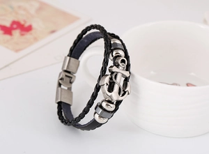 Close-up of multilayer leather bracelet featuring a silver anchor charm and magnetic clasp