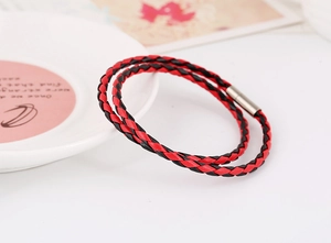 Detail of red and black braided leather bracelet with silver magnetic cylinder clasp