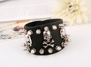 Close-up of black leather punk bracelet featuring silver metal spikes and skull charms