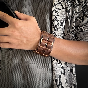 Dettaglio del bracciale largo in pelle marrone vintage con fibbia in metallo dorato