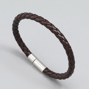 Primo piano di un bracciale in pelle PU intrecciata marrone scuro con chiusura in metallo