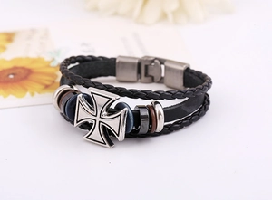 Détail d'un bracelet en cuir multicouche avec pendentif croix argentée et perles
