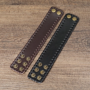 Detail of woven leather bracelets in black and brown with vintage bronze snap buttons