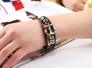 Detail of multi-layer leather bracelet with bronze anchor charm on a model's wrist