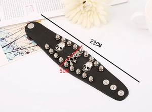 Detail of punk leather bracelet with silver skull charms and metallic studs, 23cm length