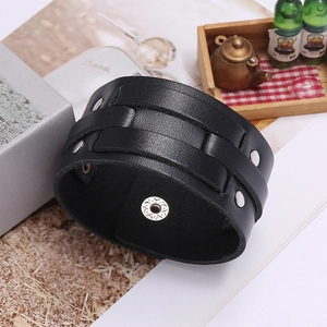 Detail of vintage black leather bracelet with silver studs and metal snap closure
