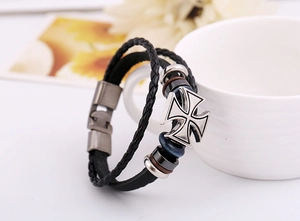 Détail du bracelet punk en cuir avec croix de fer et perles sur une tasse blanche