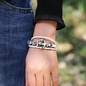 Detailed view of multilayer white braided leather bracelet with vintage silver anchor charm