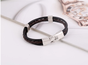 Detail view of a triple-layer braided leather bracelet with silver polished metal buckle