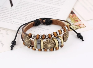 Detail of vintage multilayer leather beaded bracelet with metal charms and adjustable cord