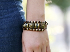Detail of vintage beaded leather bracelet with star motif charms and wooden beads on wrist