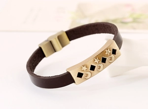 Detail of vintage brown leather bracelet with star and moon alloy metal magnetic clasp