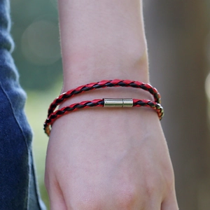 Handmade woven leather bracelet in red and black with silver magnetic clasp on wrist