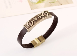 Detail of vintage brown leather bracelet featuring bronze male and female symbols clasp