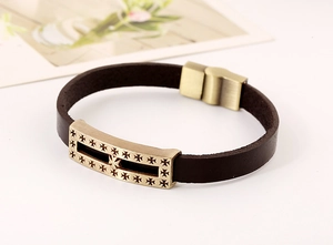 Macro shot of brown leather bracelet with bronze Gothic cross and magnetic metal clasp