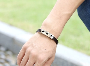 Close-up of vintage brown leather bracelet with star-patterned bronze metal on a wrist