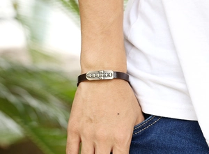 Close-up of punk style leather bracelet featuring a vintage metal skull cross decoration
