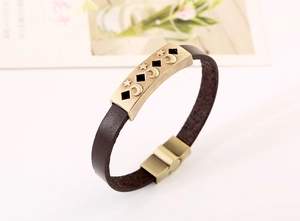 Macro detail of dark brown leather bracelet with antique moon and star metal piece