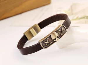 Macro shot of punk leather bracelet with bronze skull charm and magnetic buckle