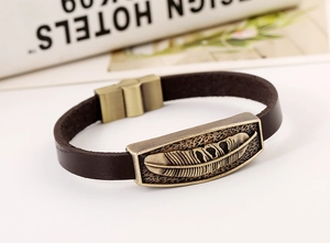 Close-up of vintage brown leather bracelet featuring bronze feather metal ornament