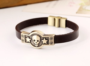 Détail d'un bracelet en cuir marron vintage avec plaque en bronze à tête de mort