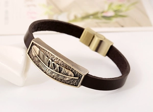 Detailed view of leather bracelet with vintage bronze feather plate and magnetic buckle