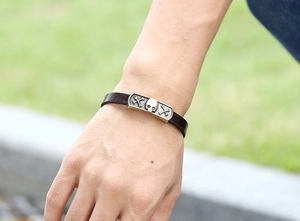 Detail of vintage skull embossed leather bracelet on wrist with a punk rock bronze finish