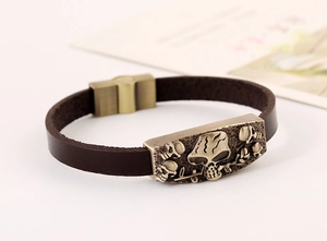 Dettaglio del bracciale punk in pelle vintage con rilievo di teschio in bronzo e chiusura magnetica