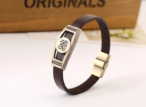 Macro detail of retro brown leather bracelet with spider relief on antique bronze metal