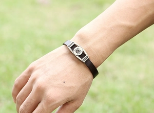 Macro detail of men's leather bracelet with vintage spider emblem and silver clasp