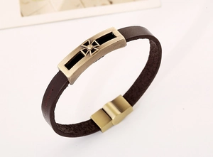 Detail of genuine brown leather bracelet with bronze cross charm and magnetic clasp