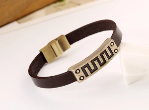 Macro view of vintage brown leather bracelet with geometric wavy metal pattern