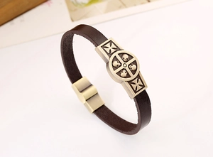Dettaglio bracciale punk in pelle con ciondoli a teschio in bronzo e chiusura magnetica
