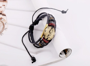 Détail macro du bracelet Gémeaux en cuir avec breloque en bronze antique et corde tressée