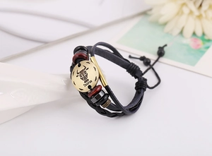Detailed view of Taurus leather bracelet with bronze charms and braided cords