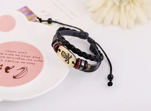 Detail of vintage braided leather bracelet with bronze skull plaque and adjustable cord