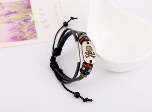 Detail of a vintage skull leather bracelet with bronze charms and colorful beads