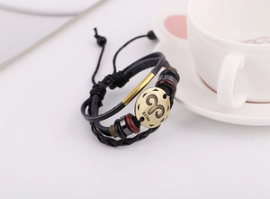 Vista macro de pulsera de cuero multicapa Aries con colgante de bronce y cuentas de madera