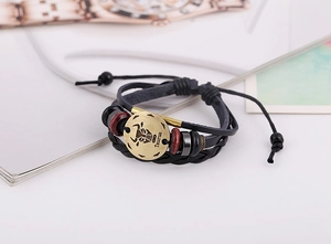 Close-up of a multilayer Taurus leather bracelet with bronze zodiac charm and wood beads