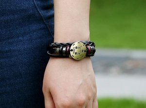 Macro detail of Libra zodiac symbol engraved on vintage leather braided bracelet
