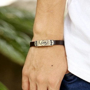 Bracelet en cuir marron foncé avec breloque cœur Love vintage porté au bras