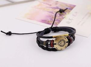 Macro shot of Leo zodiac leather bracelet with antique bronze charm and braided details
