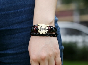 Close-up of leather Taurus bracelet with bronze metal charm on a model wrist